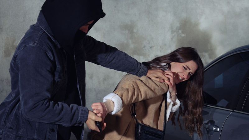 Thief trying to steal woman's phone on parking lot. Self defense concept